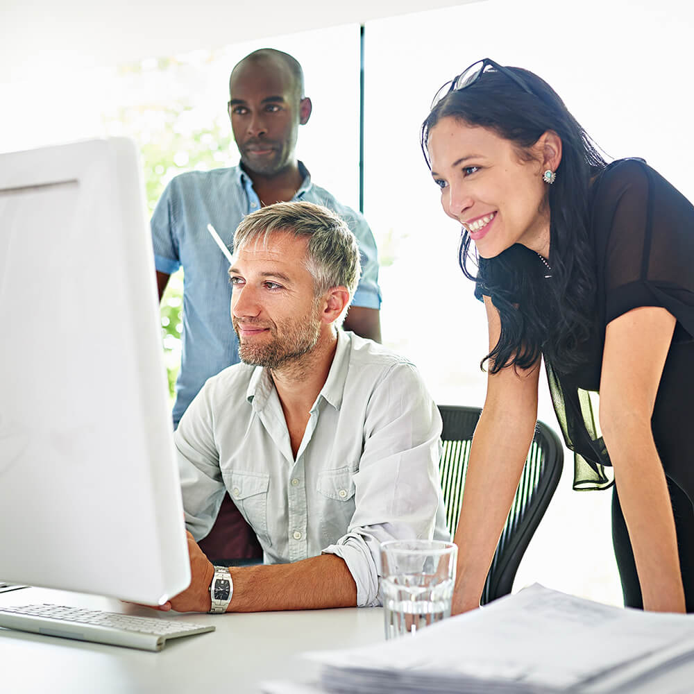 3 coworkers looking at screen 2