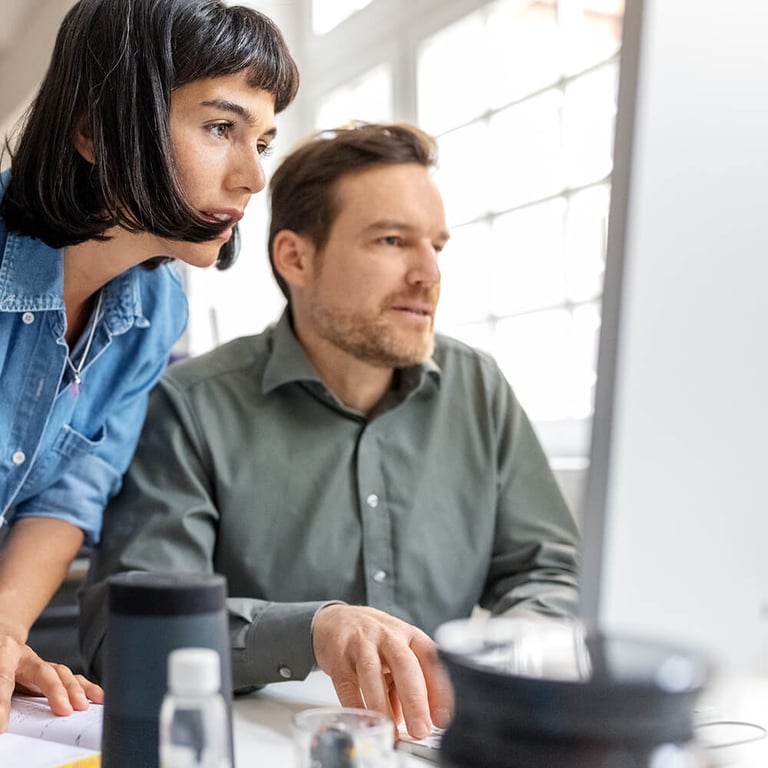 two coworkers looking at desktop